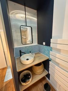 un baño con lavabo y espejo en LOFT DES SABLES - Loft moderne à 50m de la plage, en Plouguerneau