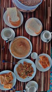 a group of plates of food on a wooden table at The Backpackers' Nest Hunza in Hunza