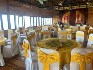 a banquet hall with white chairs and tables with bows at Khu sinh thái Ecolodge Kê Nênh Điện Biên in Ban Hin Lom
