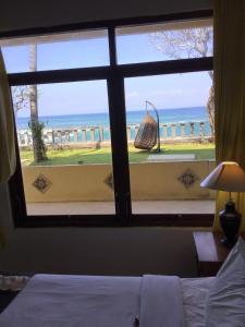 a bedroom window with a view of the ocean at Bali Palms Resort-412 in Candidasa