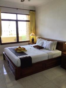 a bedroom with a large bed with a large window at Bali Palms Resort-412 in Candidasa +16 photos