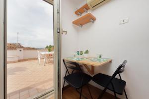 a small table and chairs in a room with a balcony at Magic Trastevere suite on roof terrace in Rome +104 photos