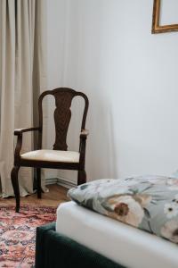 a bedroom with a chair next to a bed and a bedskirts at Ferienwohnungen "Hermann & Lucy" in Bad Muskau