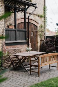a picnic table and a bench in front of a building at Ferienwohnungen "Hermann & Lucy" in Bad Muskau