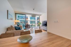 una sala de estar con una mesa y un sofá en Cond Bayline - Pool - Gyn - SPA - Peixe Balão - BY BEDZY, en Armação de Pêra