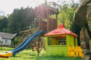 a playground with a slide and a play house at Agro Domki Pod Jesionem in Kudowa-Zdrój