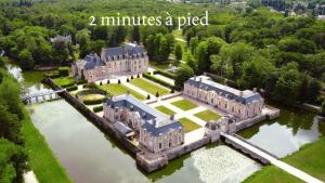 an aerial view of a large mansion in the water at La Petite Maison Solognote, au pied du Château in La Ferté-Saint-Aubin