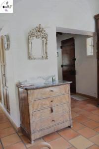a wooden dresser in a room with a mirror on the wall at Bastide provençale avec piscine privée au cœur de la nature Proche Cassis et Aix-en-Provence in Belcodène +63 photos