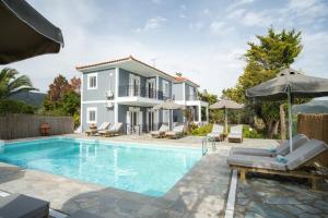 a villa with a swimming pool and a house at Dryoussa Apartments in Mesókampos