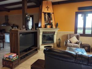 salon z kanapą i kominkiem w obiekcie Casa Rural La Alcazaba w mieście El Robledo