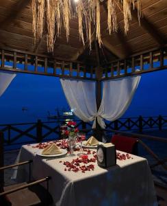 a table with a white table cloth with flowers on it at Pasa Tatil Koyu in Akcaabat