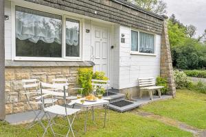 a house with chairs and a table in front of it at Finest Retreats - Lanteglos Villa in Camelford +10 photos