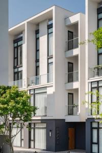 an apartment building with balconies and a tree at kk villa in Dongshan