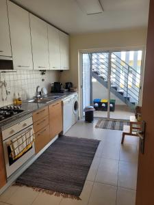 a kitchen with a sink and a stove top oven at A Cabaninha - T2 Cabanas Beach in Tavira