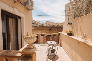 a small balcony with a table and a vase at La Casa Di Pinocchio in Enna