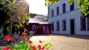 a courtyard with red flowers in front of a building at La Torre Hotel in Moie