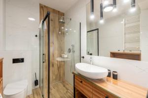 a white bathroom with a sink and a shower at Seaside Sun Seasons 24 Apartments in Pogorzelica with Parking by Noclegi Renters in Pogorzelica