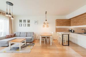a kitchen and living room with a couch and a table at Seaside Sun Seasons 24 Apartments in Pogorzelica with Parking by Noclegi Renters in Pogorzelica