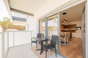 a kitchen and dining room with a table and chairs at Seaside Sun Seasons 24 Apartments in Pogorzelica with Parking by Noclegi Renters in Pogorzelica