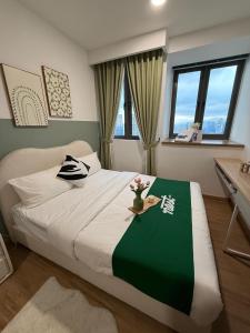 a bedroom with a large bed with a green and white blanket at Nest Retreat Kuala Lumpur in Kuala Lumpur