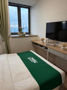 a hotel room with a bed and a desk with a television at Nest Retreat Kuala Lumpur in Kuala Lumpur