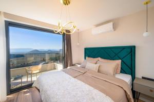 a bedroom with a bed and a large window at Luxury Villa San Rocco in Desne