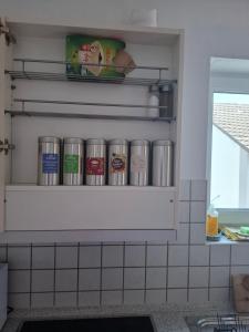 a shelf in a kitchen with cans on it at Harmony Apartment, your holiday home in Rust with balcony & river-view, 5min to Europa-Park in Rust