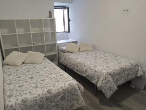 a bedroom with two beds and a window at Casa Nentis in Mucientes