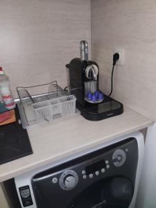 a kitchen counter with a coffee maker on top of a appliance at Fani Studio in Stara Zagora +4 photos