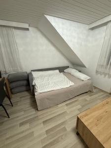 a bedroom with a bed and a couch and a table at Dachtraum Sahin in Günzburg