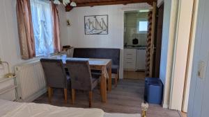 a dining room with a table and chairs and a kitchen at Waldblick 2 in Kühlungsborn +8 photos