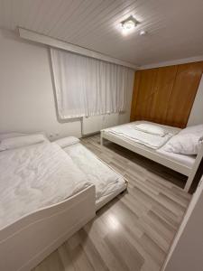 a bedroom with two beds and a window at Dachtraum Sahin in Günzburg +9 photos