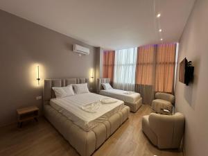 a hotel room with two beds and a couch at Luxury Hotel By Gjyshi in Qerrexhias