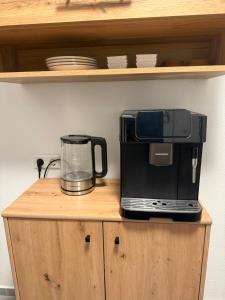 a coffee maker sitting on top of a wooden cabinet at Dachtraum Sahin in Günzburg