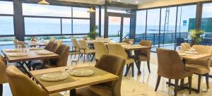 a restaurant with wooden tables and chairs and windows at istanbul Airport Kumsal Otel in Arnavutköy
