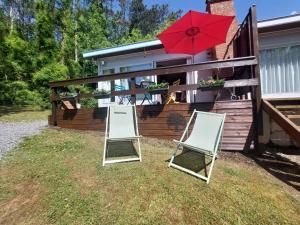 WaulsortLE PETIT CHALET - Bungalow的院子里的两把椅子和一把红伞