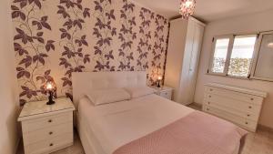 a bedroom with a white bed with a flowery wallpaper at Residence Maresol in Vieste