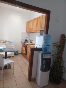 a kitchen with a table and a counter with a water cooler at Mondo House in Fiumicino