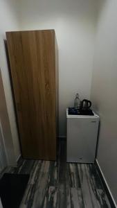 a room with a wooden door and a small refrigerator at Wadi Al Arbeieen Resort in Ḑibāb