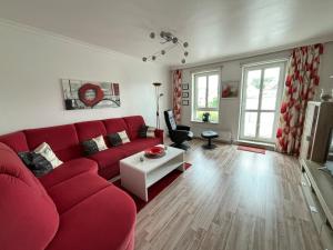 a living room with a red couch and a table at " Stadtwohnung Ausspann " in Heiligenhafen