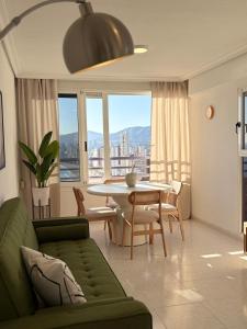 a living room with a green couch and a table at Incredible sea views in Benidorm