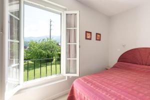 a bedroom with a bed and a large window at La Maison des Vacances in Argelès-Gazost