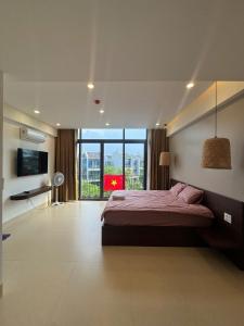 a bedroom with a large bed and a large window at Gia Hân Villa in Cam Thanh