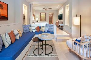 a living room with a blue couch with pillows at The Westin Resort, Costa Navarino in Romanu +37 photos