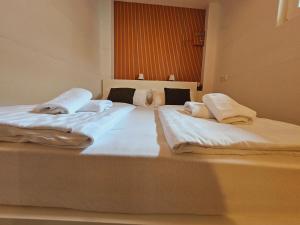 two beds in a room with white sheets and pillows at Ljubljana Center Budget Apartment in Ljubljana +9 photos