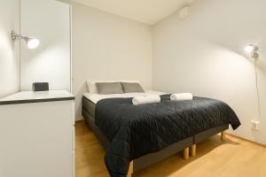 una camera con un letto e una coperta nera di Tammer Huoneistot - City Suite 3 - Public Sauna, Gym & Pool a Tampere