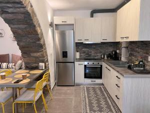 a kitchen with a table and a stainless steel refrigerator at Katoi Apartment in Loutrá