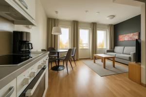 una cucina e un soggiorno con un divano e un tavolo di Tammer Huoneistot - City Suite 3 - Public Sauna, Gym & Pool a Tampere