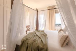 biała kanapa z zasłonami i oknem w obiekcie Villa Gran Sol by Abahana Villas w mieście Calpe