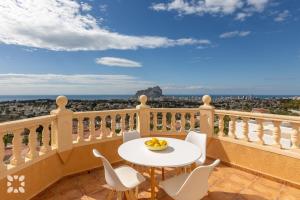 stół i krzesła na balkonie z widokiem w obiekcie Villa Gran Sol by Abahana Villas w mieście Calpe